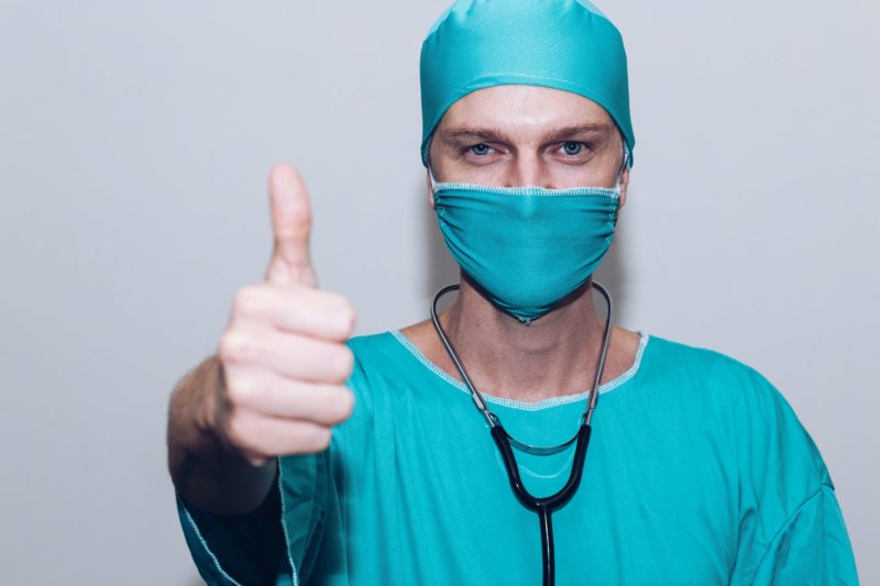 Satisfied Nurse Giving a Thumbs-Up in Medical Apparel