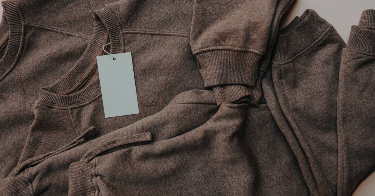A collage of brown crew neck sweatshirts lay out on the table in various sizes, ready for brand customization.