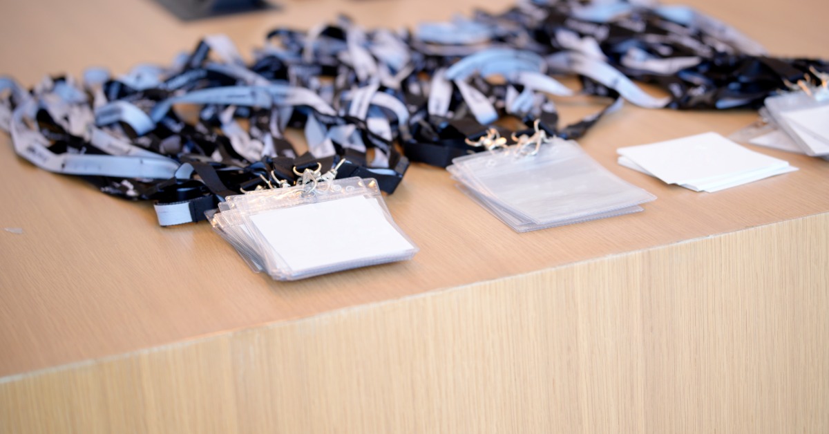 A close-up of a registration booth at a trade show with name tags attached to branded lanyards.