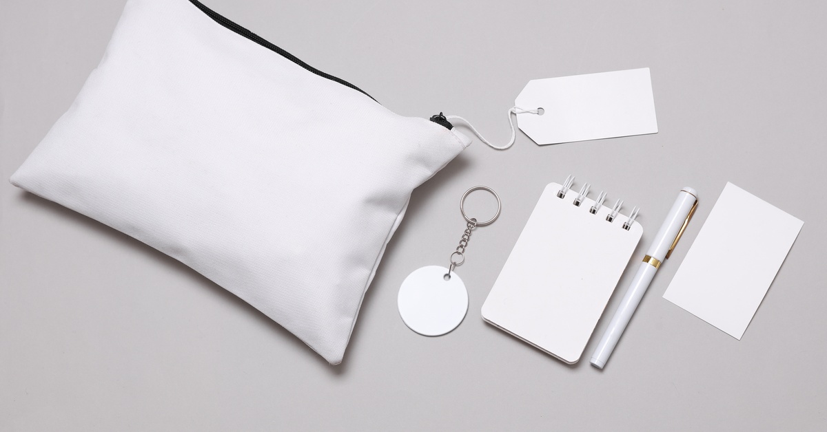 A set of promotional products sit on a gray background. The products are white and ready for customization.