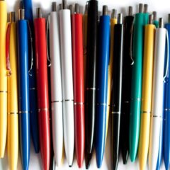 A collection of ink pens in a variety of different colors including red yellow white black and blue
